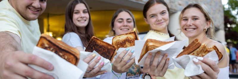 Students show off their cheese sandwiches for the camera.